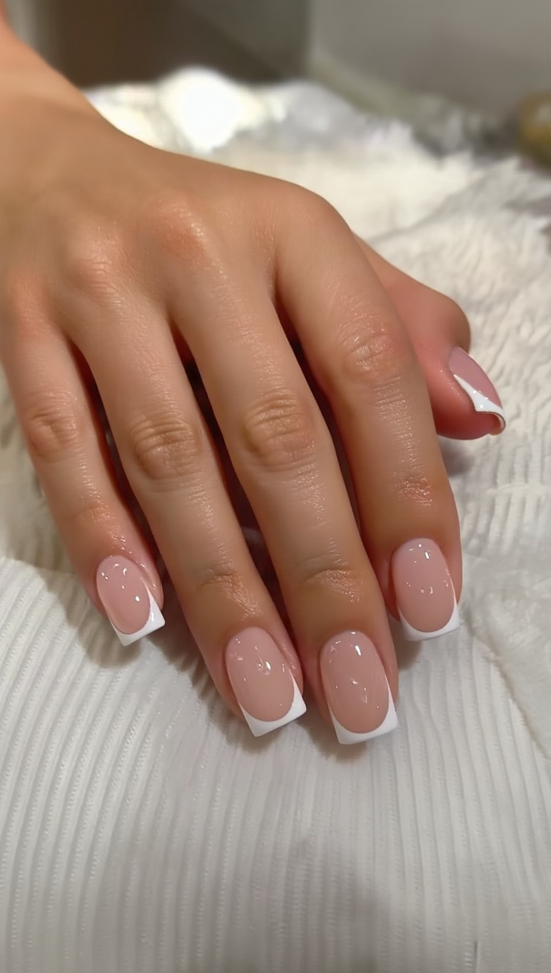 Heart french tip press-on nails on a soft aesthetic vanity table